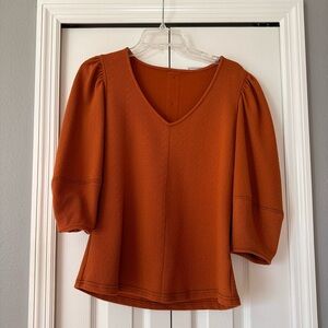 Elbow length puffy sleeve, burnt orange with cute back button detail